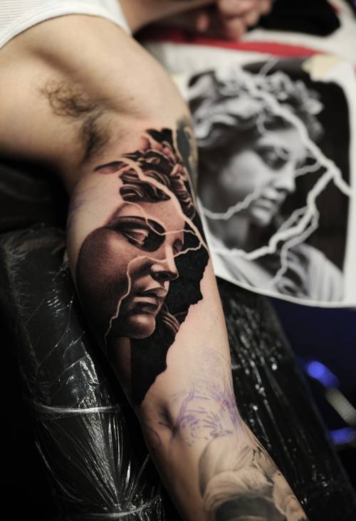 Cracked marble woman portrait, black and grey realism arm tattoo
