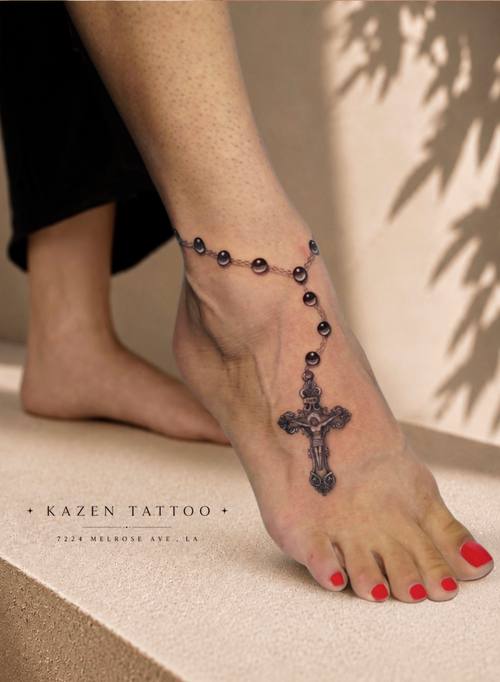 Rosary and cross wrapped around the ankle and foot, fine line tattoo by Amina at KAZENTATTOO, Los Angeles