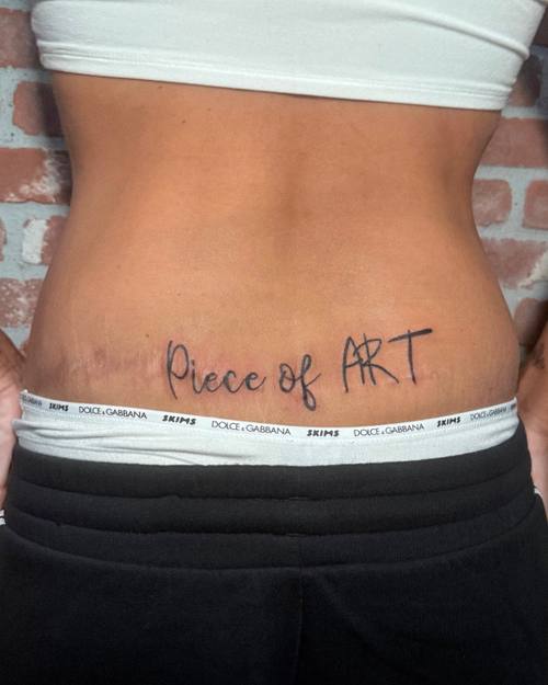 Script across the lower back by Amina at KAZENTATTOO, Los Angeles