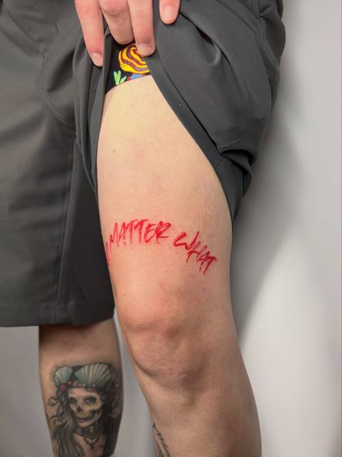Script in red ink on the thigh by Amina at KAZENTATTOO, Los Angeles, second view