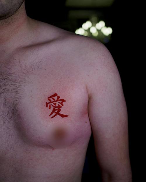 Single character in red ink on the chest by Amina at KAZENTATTOO, Los Angeles