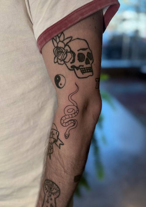 Skull with botanical work on the arm, black and grey tattoo by Amina at KAZENTATTOO, Los Angeles