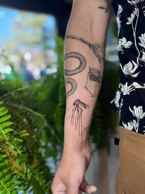 Snake with ornament on the forearm, fine line tattoo by Amina at KAZENTATTOO, Los Angeles