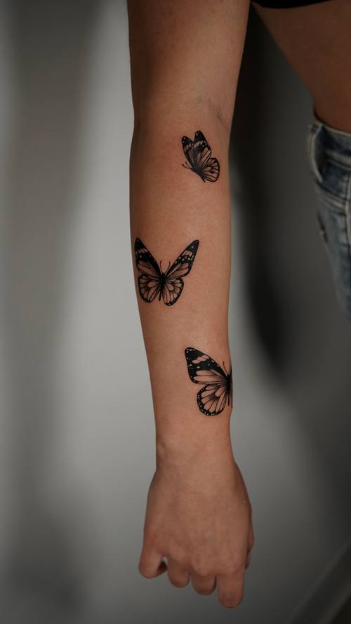 Butterflies down the forearm, fine line tattoo by Amina at KAZENTATTOO, Los Angeles