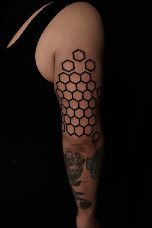 Honeycomb pattern down the upper arm, black and grey tattoo by Amina at KAZENTATTOO, Los Angeles