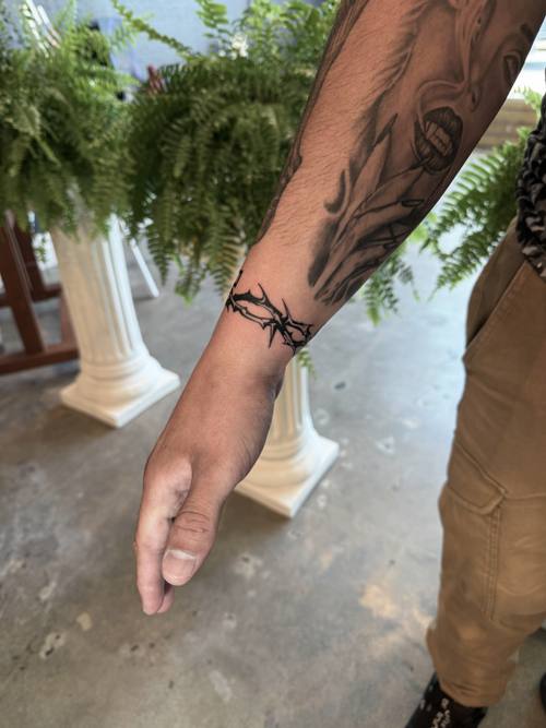 Barbed band around the wrist, fine line tattoo by Amina at KAZENTATTOO, Los Angeles