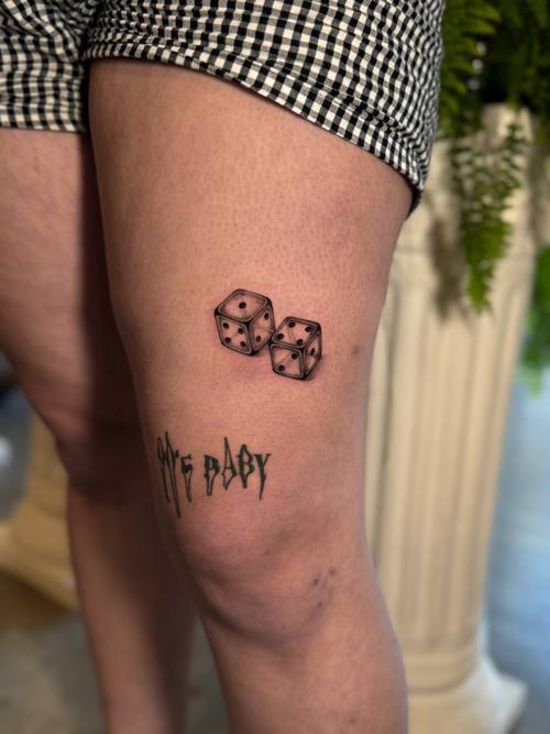 Pair of dice with lettering on the thigh by Amina at KAZENTATTOO, Los Angeles, third view
