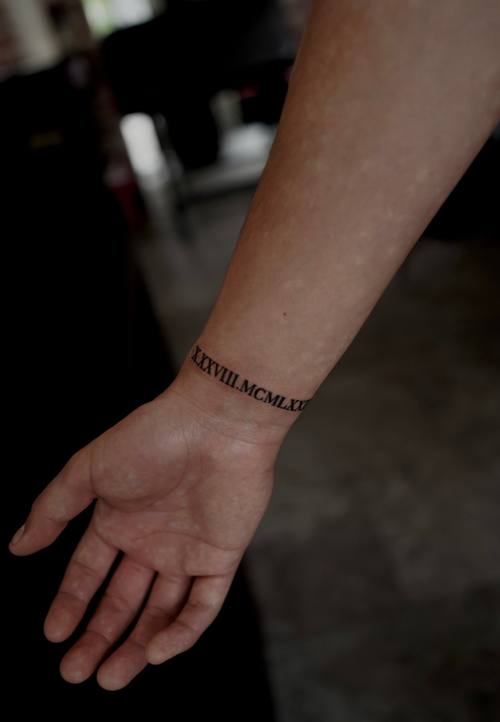 Script bracelet around the wrist, fine line tattoo by Amina at KAZENTATTOO, Los Angeles