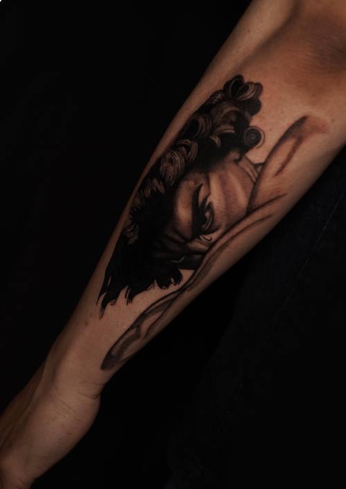 Dark figure on the forearm, black and grey tattoo by Amina at KAZENTATTOO, Los Angeles