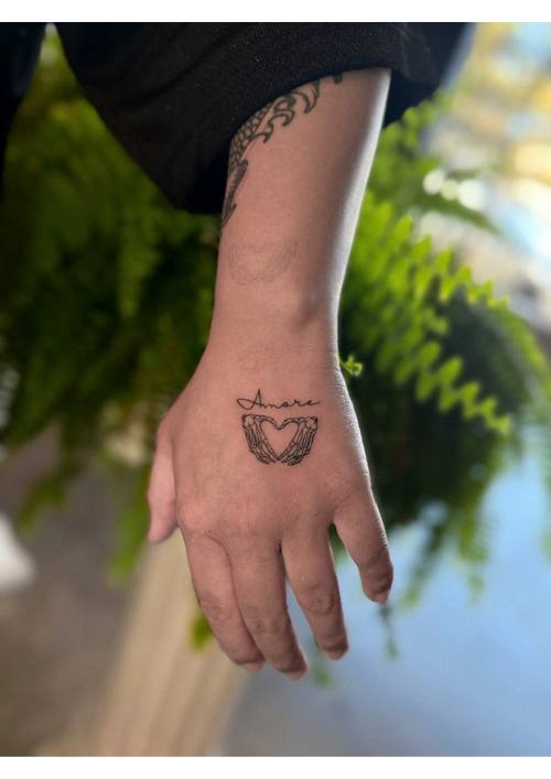 Small design on the back of the hand, fine line tattoo by Amina at KAZENTATTOO, Los Angeles
