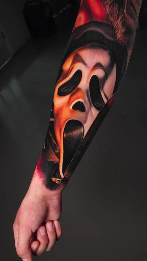 Ghost mask in flames, colour realism forearm tattoo by Livio at KAZENTATTOO, Los Angeles