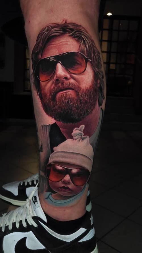 Bearded man in sunglasses with a baby in a carrier, colour realism arm tattoo by Livio at KAZENTATTOO, Los Angeles