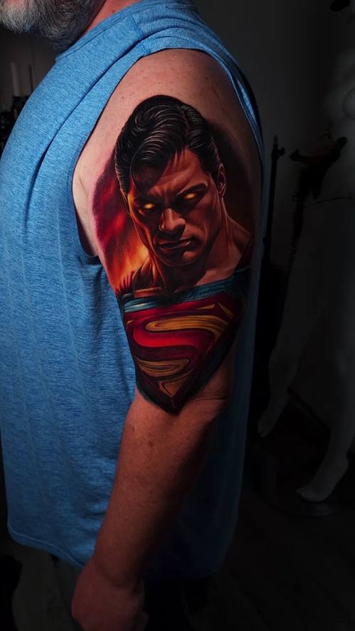 Man's portrait against a blue background, colour realism shoulder tattoo by Livio at KAZENTATTOO, Los Angeles