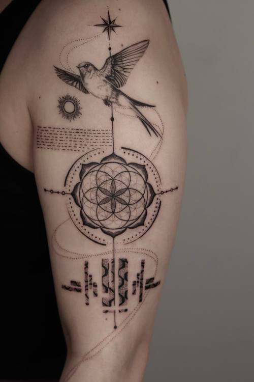 Flower of life with a swallow and script, sacred geometry upper arm tattoo by Marrie at KAZENTATTOO, Los Angeles