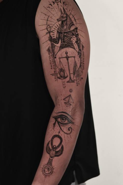 Seated Anubis with an ankh and the eye of Horus, fine line arm tattoo by Marrie at KAZENTATTOO, Los Angeles