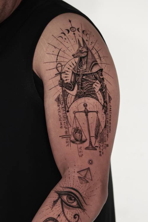 Anubis with sun rays and the eye of Horus, fine line upper arm tattoo by Marrie at KAZENTATTOO, Los Angeles, second view