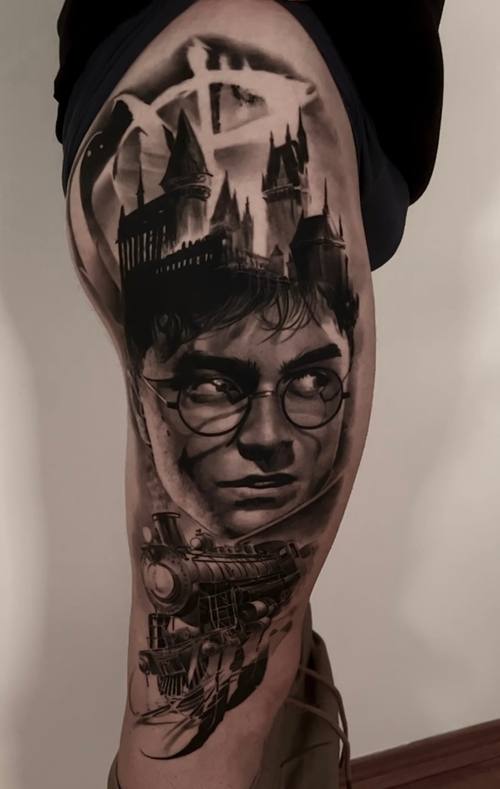 Portrait of a young man in round glasses with a castle skyline, black and grey arm tattoo by Marko at KAZENTATTOO, Los Angeles