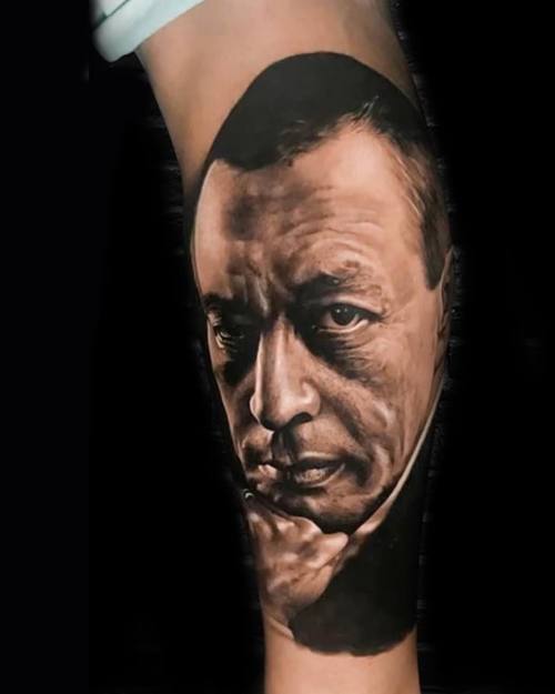 Portrait of a man in a suit, black and grey realism calf tattoo by Nihat at KAZENTATTOO, Los Angeles