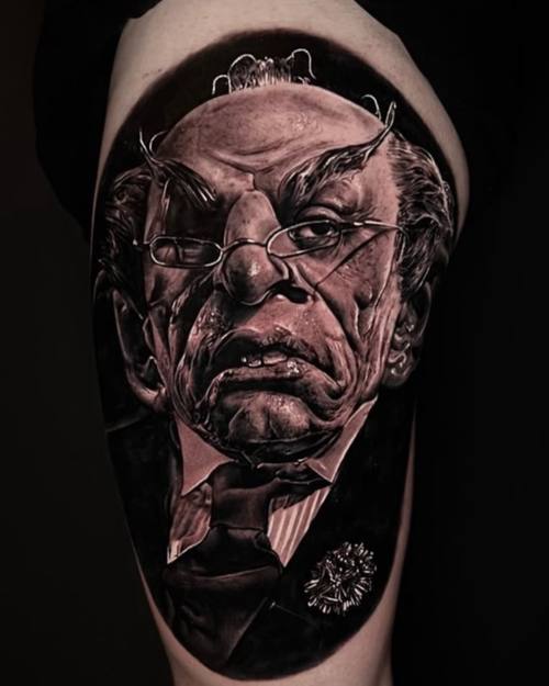 Portrait of a stern man in glasses and a hat, black and grey realism calf tattoo by Nihat at KAZENTATTOO, Los Angeles