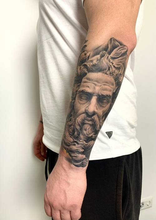 Black and grey realism portrait of a bearded helmeted figure on the arm by Padre at KAZENTATTOO, Los Angeles