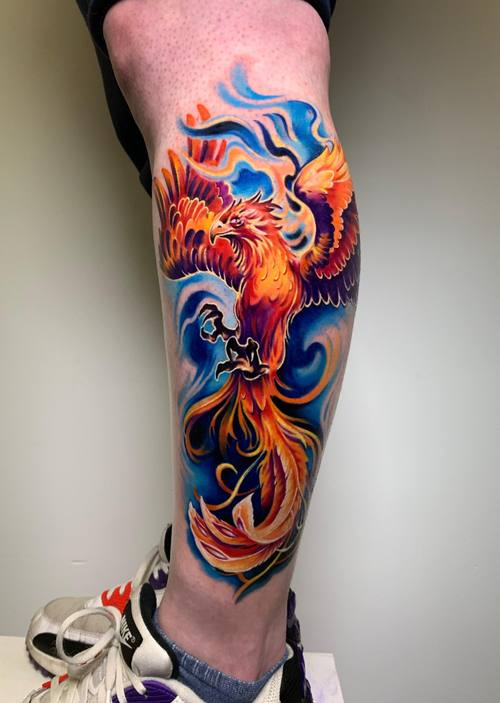 Bright phoenix in swirling blue, orange and red on the calf by Padre at KAZENTATTOO, Los Angeles