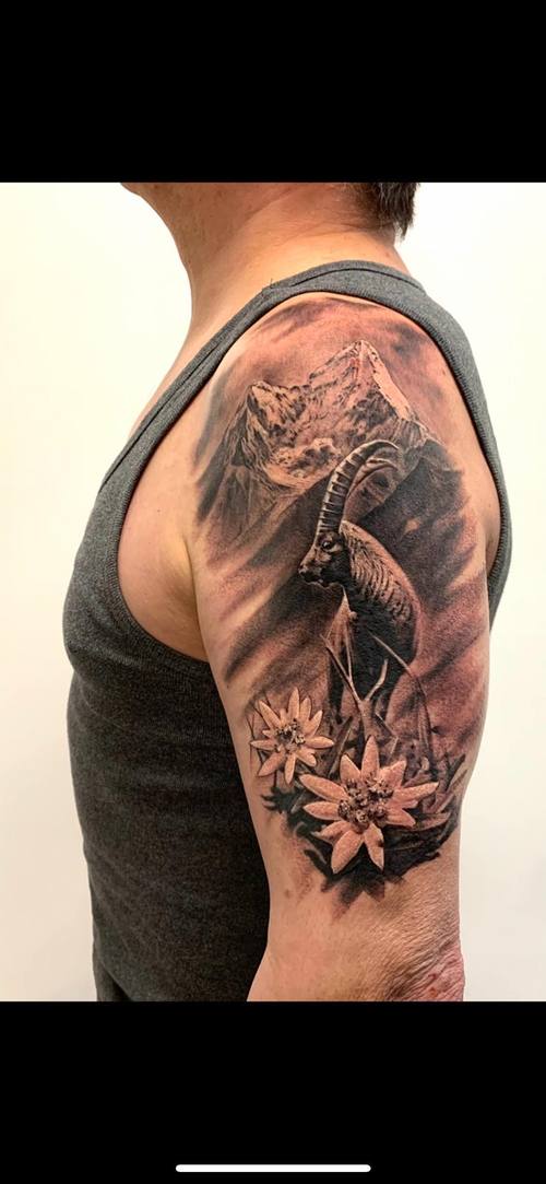 Black and grey mountain, mountain goat and flowers on the upper arm by Padre at KAZENTATTOO, Los Angeles