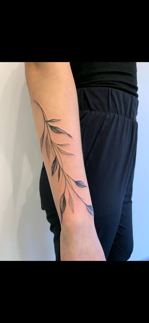 Fine line botanical branch along the forearm by Padre at KAZENTATTOO, Los Angeles