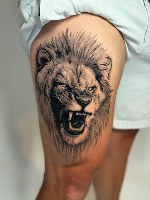 Black and grey roaring lion realism on the thigh by Padre at KAZENTATTOO, Los Angeles