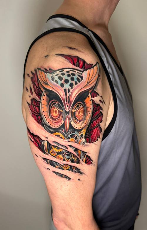 Surreal color mechanical owl with glowing gears on the shoulder by Padre at KAZENTATTOO, Los Angeles