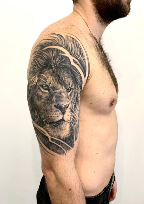 Black and grey lion with geometric lines on the shoulder by Padre at KAZENTATTOO, Los Angeles