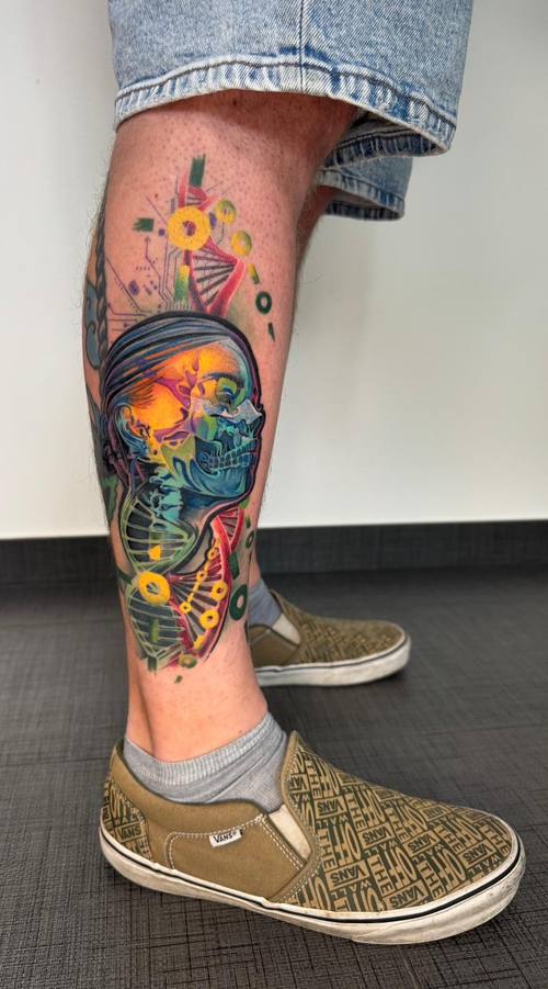 Surreal color skull face with DNA double helix and circuit patterns on the calf by Padre at KAZENTATTOO, Los Angeles