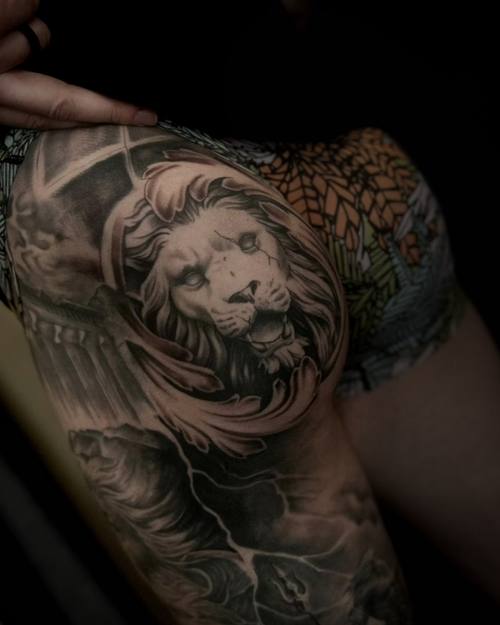 Lion portrait in an ornamental frame, black and grey hip tattoo by Sam at KAZENTATTOO, Los Angeles