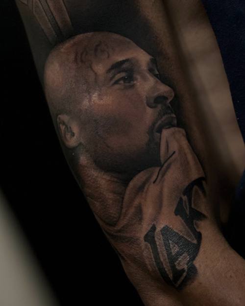 Portrait of a basketball player looking upward, black and grey realism forearm tattoo by Sam at KAZENTATTOO, Los Angeles