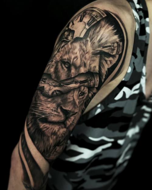 Lion with a pocket watch and a city skyline, black and grey upper arm tattoo by Sam at KAZENTATTOO, Los Angeles