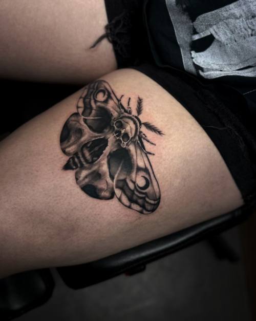 Moth with a skull pattern on its wings, black and grey thigh tattoo by Sam at KAZENTATTOO, Los Angeles
