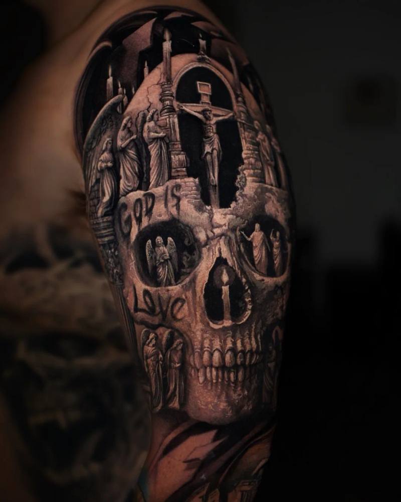Skull with crucifix and cathedral scenes, God Is Love upper arm tattoo