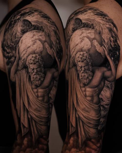 Classical statues in flowing robes, black and grey upper arm tattoo