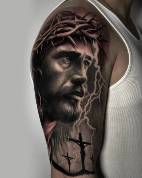 Jesus with crown of thorns and lightning, black and grey upper arm tattoo