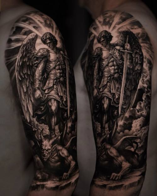 Skull with crucifix, angels and columns, black and grey upper arm tattoo