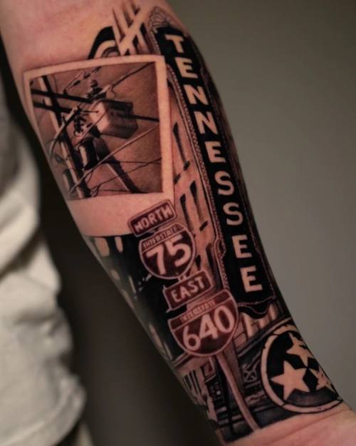 Tennessee road signs and city scene, black and grey forearm tattoo